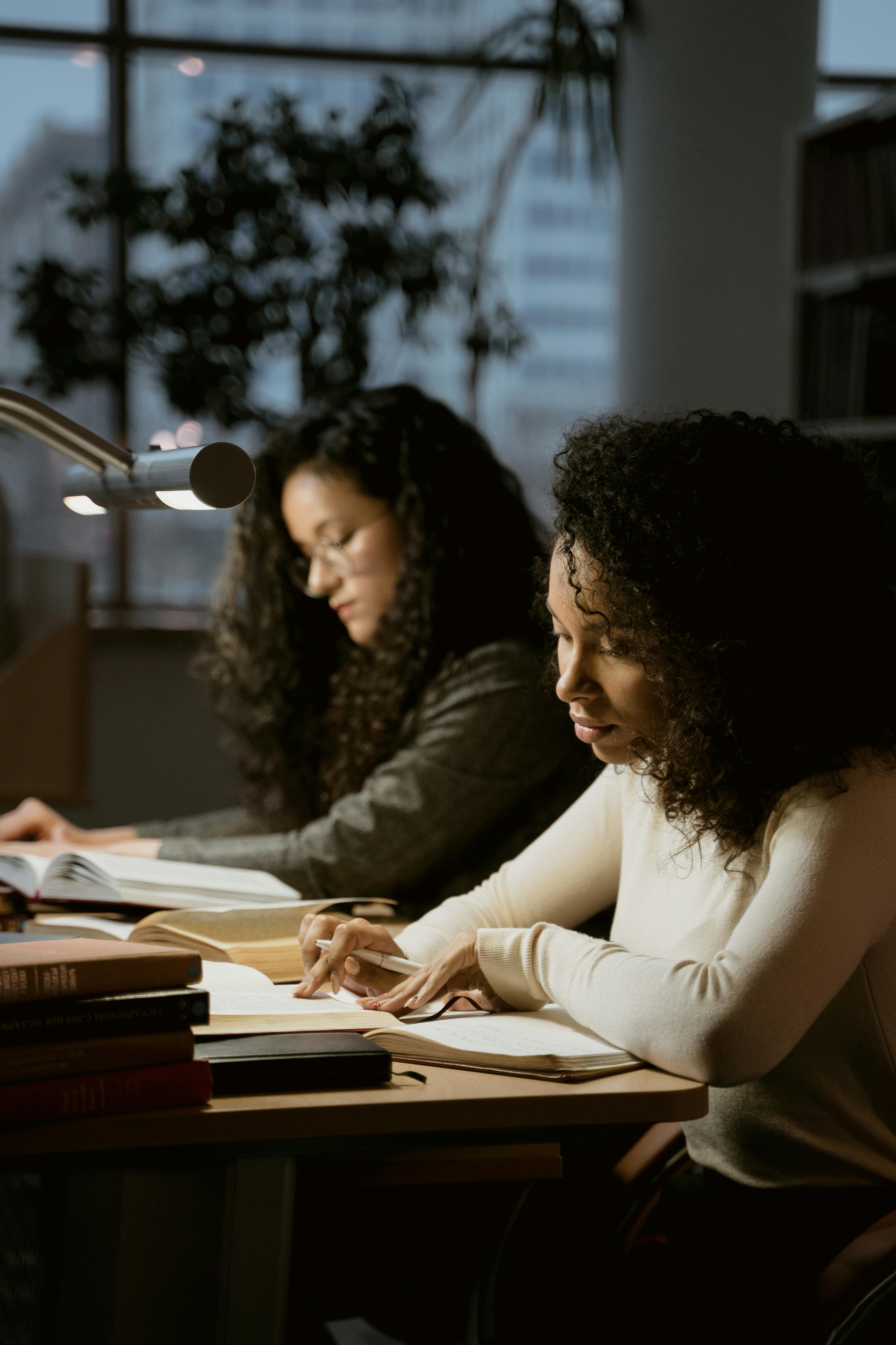 Two pre-nursing students planning course sequence and exam preparation at a study table.